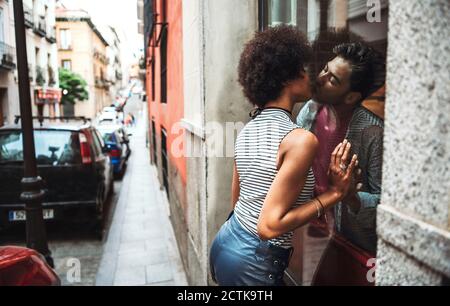 Romantisches Paar küsst durch Fenster des Restaurants Stockfoto