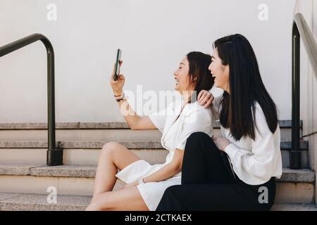 Kollegen machen Selfie, während sie auf der Treppe sitzen Stockfoto