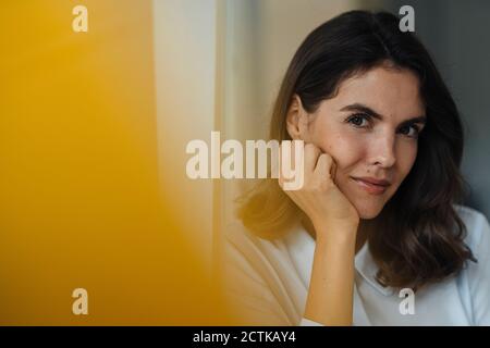 Junge Frau mit Kopf in den Händen, die im Büro steht Stockfoto