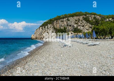 Griechenland, Nord-Ägäis, Reihen von Sonnenschirmen und leeren Liegestühlen am Strand von Tsambou im Sommer Stockfoto