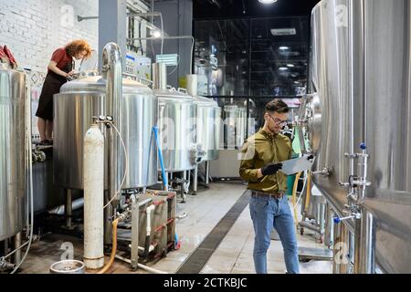 Mann und Frau arbeiten in der handwerklichen Brauerei Stockfoto