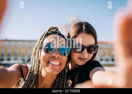 Lächelnde Frau beim Selfie mit Freundin im Praca do Comercio, Lissabon, Portugal Stockfoto