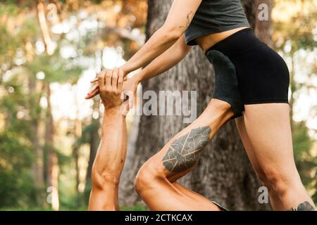 Männliche und weibliche Athleten üben acroyoga im Park Stockfoto