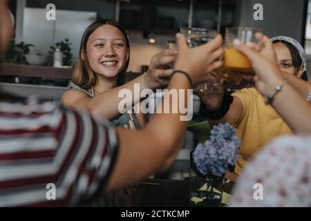 Eine Gruppe von Teenagern klirrrende Gläser beim hausgemachten Brunch Stockfoto