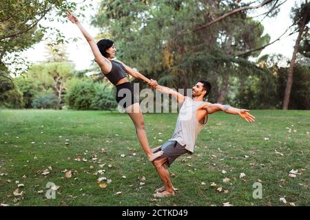 Paar üben acroyoga im Park Stockfoto