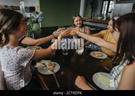 Eine Gruppe von Teenagern klirrrende Gläser beim hausgemachten Brunch Stockfoto