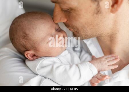 Vater umarmt seinen schlafenden Jungen in Armen zu Hause Stockfoto