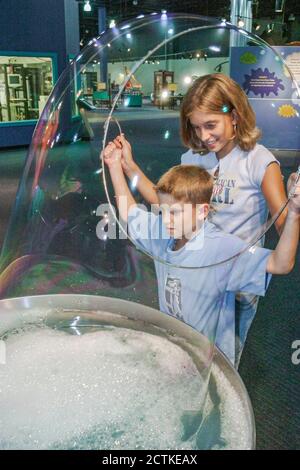 Huntsville Alabama, Sci-Quest Hands-on Science Center, innen, junge Mädchen Bruder Schwester Geschwister machen riesige Seifenblasen Stockfoto