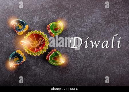 Draufsicht über Ton beleuchtet Licht ein Feuer bereits auf Diya oder Öllampe, Studio auf Beton Hintergrund geschossen, Dekoration des Hinduismus rangoli, Happy celebra Stockfoto