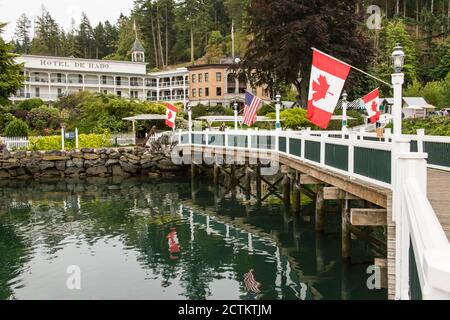 Roche Harbour, Washington, USA. Amerikanische und kanadische Flaggen säumen den Pier, der von den Docks zum Hotel de Haro führt. (Nur für redaktionelle Zwecke) Stockfoto