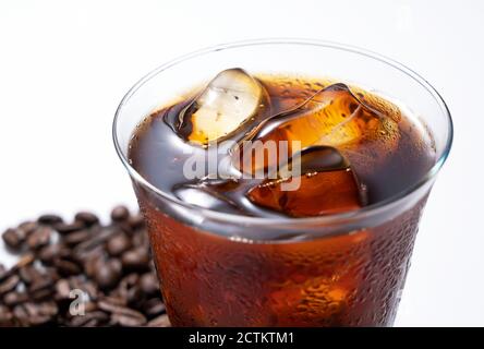Kalter Kaffee und Kaffeebohnen in einem Glas auf einem Weißer Hintergrund Stockfoto
