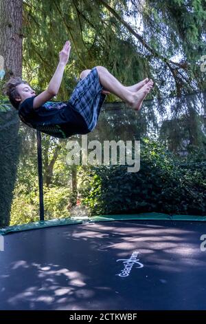 Lynwood, Washingtin, USA. 17-jähriger Junge hüpft und macht Flips auf seinem Trampolin. Stockfoto