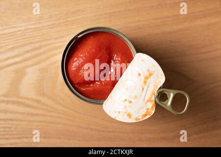 Ganze Tomatendosen auf einem Holzhintergrund Stockfoto