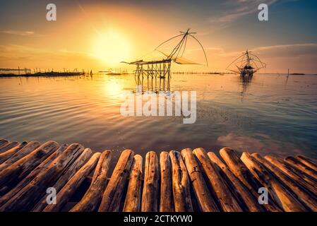 Traditionelle quadratische Netzgeräte bei Sonnenaufgang in Pakpra Canal, Phatthalung, Thailand Stockfoto