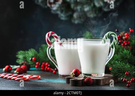 Heißer Winter-Weißgetränk mit Candy Sticks, Weihnachten oder Neujahr Dekorationen, dunkler Hintergrund, rustikalen Stil, Kopierraum Stockfoto