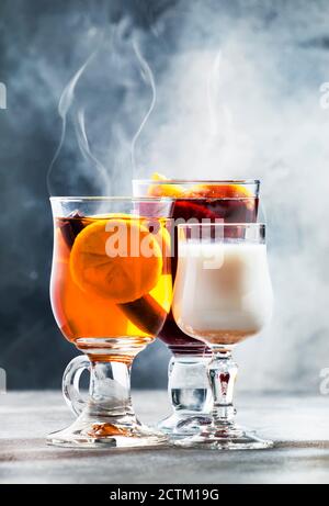 Auswahl an heißen alkoholischen Cocktails im Herbst oder Winter - Glühwein, Glogg, Grog, Eierlikör, warmes Ingwer Ale, gebutterter Rum, Punsch, Apfelmost Stockfoto