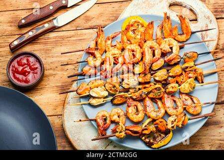 Gegrillte Garnelen und Muscheln auf Holzstäbchen Stockfoto