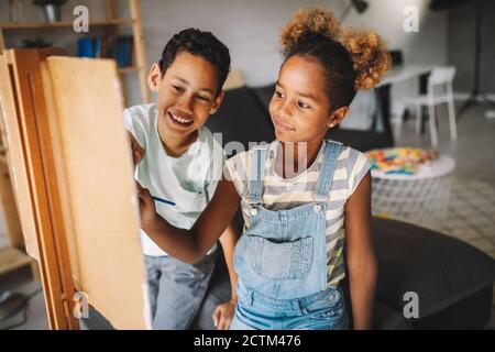 Süße Kinder Mädchen und Jungen malen zusammen. Bildung, Kunst, Spaß und Kreativität. Stockfoto