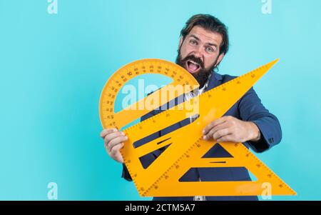 Bestehen Sie die Mathe-Prüfung. Lernen Sie das Thema. Glücklicher Mann mit Bart mit Dreieck und Winkelmesser. Studium der Messung. Formale Bildung. Männliche Schüler in Mathematik Schulunterricht. Copy space. Stockfoto