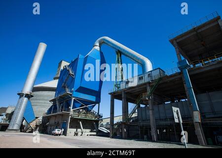 Mynaral/Kasachstan - April 23 2012: Moderne Zementanlage von Jambyl. Trichter, Silo und Pflanzenkamin am blauen Himmel. Panoramaansicht. Stockfoto