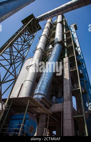 Mynaral/Kasachstan - April 23 2012: Moderne Zementanlage von Jambyl. Der Turm, Silo und Rohre am blauen Himmel. Stockfoto