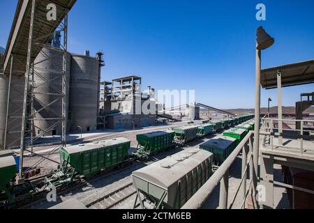 Mynaral/Kasachstan - April 23 2012: Zementanlage von Jambyl. Güterbahnterminal. Training auf Silo und Werksgebäude Hintergrund. Stockfoto