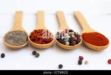 Gewürzmischung in einem Holzlöffel auf weißem Holzhintergrund. Flatlay. Stockfoto