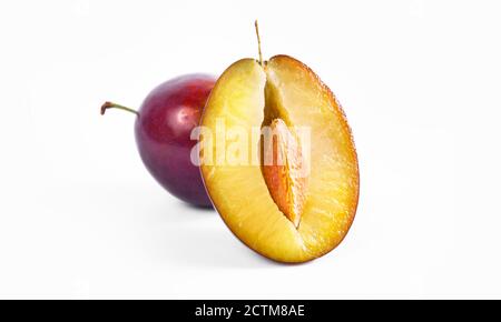 Nahaufnahme mit Pflaume in der Hälfte. Oragnic süße Pflaumen frisch und lecker. Frischer Obstsnack. Isoliert auf weißem Hintergrund. Stockfoto