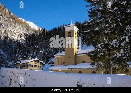 Campodolcino, Provinz Sondrio, Lombardei, Italien. St. Johannes der Täufer Kirche. Bereits in der '400, wurde Erweiterung, Restaurierung und Modifikationen an der aktuellen Struktur mit 3 Schiffen. Im Inneren befinden sich einige wertvolle Werke, wie zwei geschnitzte Holzaltäre aus dem 18. Jahrhundert, der Hochaltar und der Altar des Kruzifix. Hier wurde der kleine Luigi Guanella am 20. Dezember 1842 getauft. Wurde Heiliger im Jahr 2011. Stockfoto