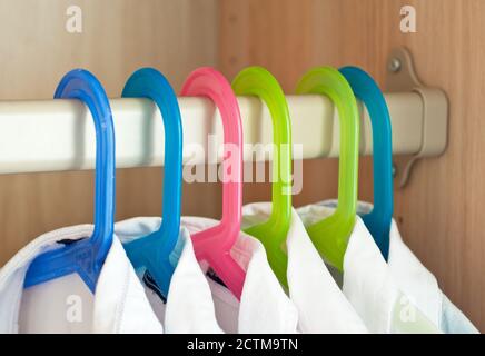 Weiße Hemden hängen im Schrank an Kleiderbügeln Stockfoto