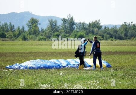 Tandem Fallschirm springen Emotionen kurz nach dem Moment der Landung bunten Schuss in Slavnica, Slowakei am 19. September 2020. Action-Kamera verwenden. Stockfoto