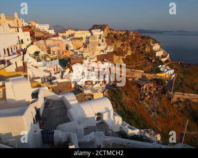 Massen von Touristen beobachten den Sonnenuntergang von der Burg von Agios Nikolaos, Oia, Santorini Stockfoto