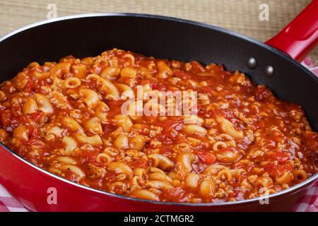 Köstliche Gulasch und Nudeln Kochen in einer roten Pfanne Stockfoto