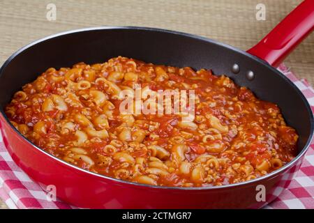 Köstliche Gulasch und Nudeln Kochen in einer roten Pfanne Stockfoto