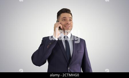 Lächelnder junger Geschäftsmann, der mit seinem Handy telefoniert Ein Stockfoto