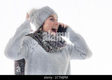 Hispanic Frau trägt einen warmen Pullover und Hut, Gespräch am Telefon sehr aufgeregt Stockfoto