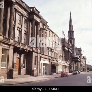 60er Jahre, historisch, George Street, Edinburgh, Schottland, Großbritannien, mit Autos aus der Zeit geparkt auf der Straße vor dem George Hotel. Geplant als Teil der "New Town" im 18. Jahrhundert von James Craig, die Straße ist die wichtigste Durchgangsstraße der Stadt, mit seinem Namen von König George III.. Stockfoto