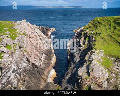 Trolie Geo bei Aywick im Osten der Insel Yell in Shetland UK. Das Grundgestein ist vom Yell Sound 'Division' - Gneiss - metamorphes Grundgestein fo Stockfoto