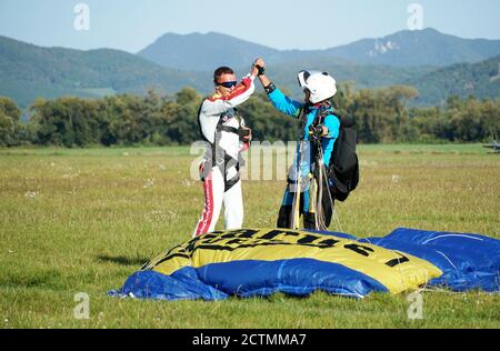 Tandem Fallschirm springen Emotionen kurz nach dem Moment der Landung bunten Schuss in Slavnica, Slowakei am 19. September 2020. Action-Kamera verwenden. Stockfoto