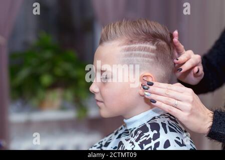 Seitenansicht Nizza europäischen Jungen immer Frisur im Friseursalon.Friseur macht Eine Frisur für einen Jungen Stockfoto