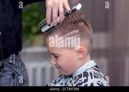 Seitenansicht Nizza europäischen Jungen immer Frisur im Friseursalon.Friseur macht Eine Frisur für einen Jungen Stockfoto