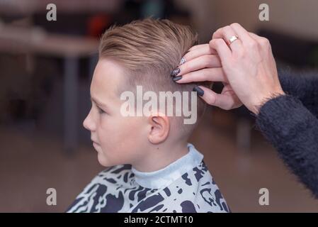 Seitenansicht Nizza europäischen Jungen immer Frisur im Friseursalon.Friseur macht Eine Frisur für einen Jungen Stockfoto