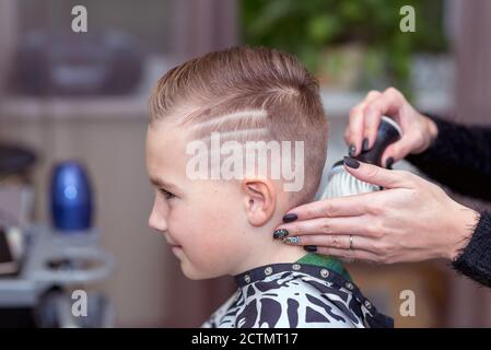 Seitenansicht Nizza europäischen Jungen immer Frisur im Friseursalon.Friseur macht Eine Frisur für einen Jungen Stockfoto