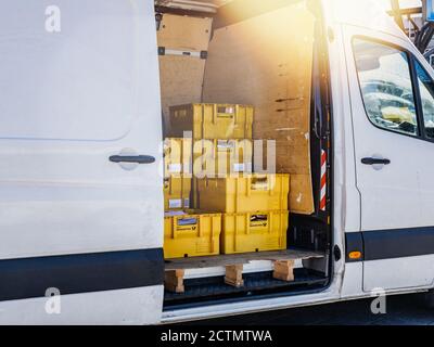 Hamburg, Deutschland - 20. März 2020: Seitenansicht des Paketzustellwagens mit gelben Schachteln mit Briefen und Kartonpaketen von Deutsche Post DHL - weißes Mercedes-Benz Paket die Hamburger Innenstadt Stockfoto