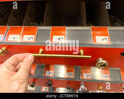 Frankfurt, Deutschland - 18. Jan 2020: POV männliche Hand am goldenen Messing Küchenschrankgriff im baumarkt Stockfoto