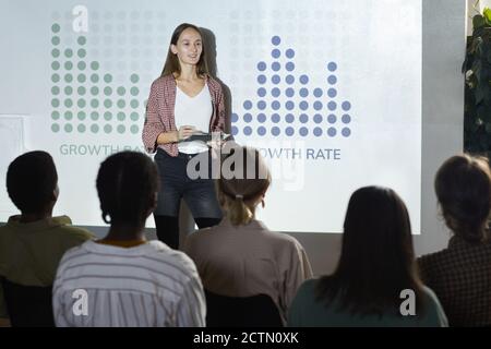 Porträt der zeitgenössischen jungen Frau Statistiken und Wachstumsrate während der sozialwissenschaftlichen Konferenz, copy space Stockfoto