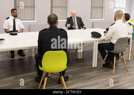 Premierminister Boris Johnson setzt sich während eines Besuchs des Polizeihauptquartiers Northamptonshire in Northampton zusammen, um mit Polizeibeamten zu sprechen. Stockfoto