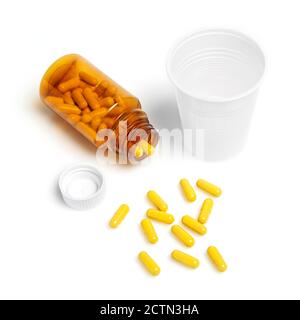 Pillen aus Flasche und Plastikglas verschüttet Stockfoto