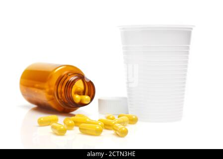 Pillen aus Flasche und Plastikglas verschüttet Stockfoto