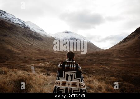 Rückansicht von unkenntlich männlichen Explorer stehend genießen Landschaft Berge im Herbst in den schottischen Highlands Stockfoto